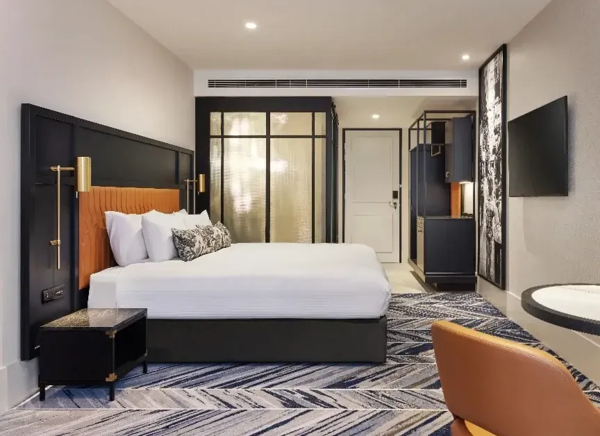 Deluxe room with king bed, seating nook and warm ambient lighting